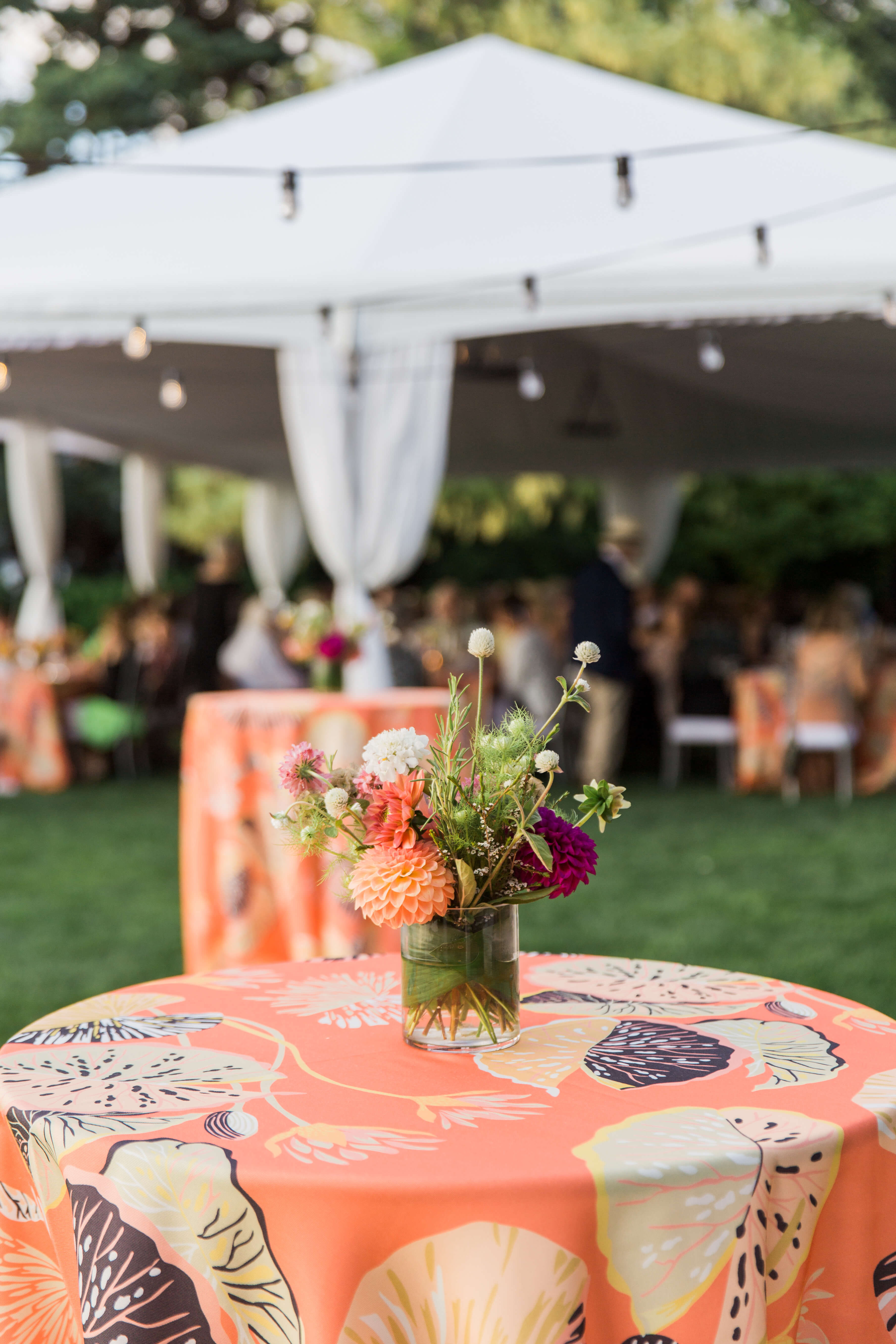 hi boy tables on the lawn adorned with small florals